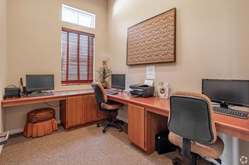 an office with two computers and two chairs